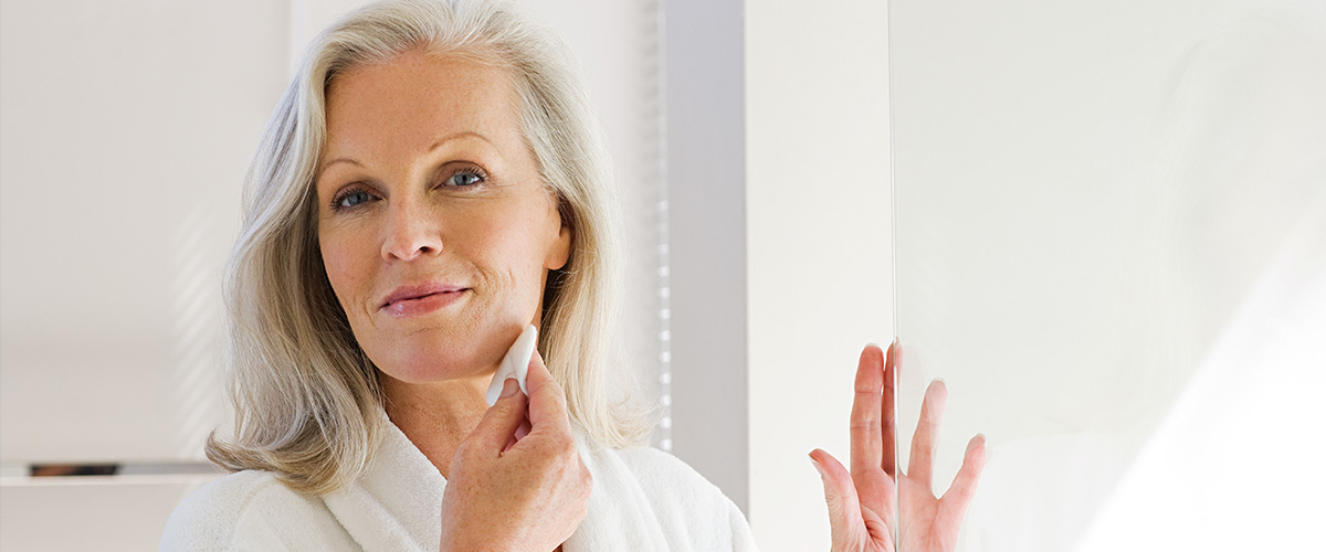 older woman cleansing face