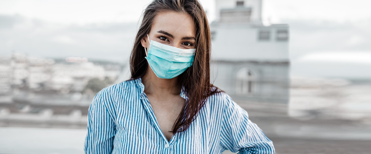 woman wearing mask in front of city views