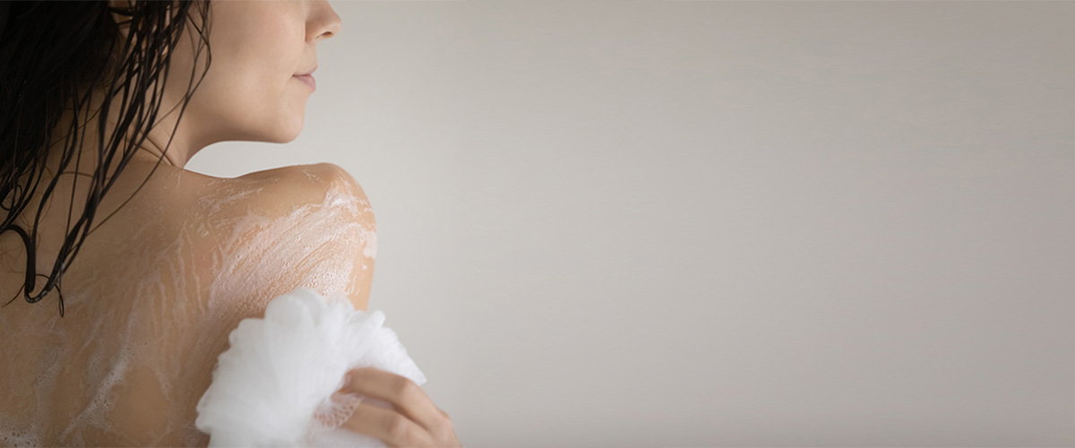 woman washing back with soap free cleanser