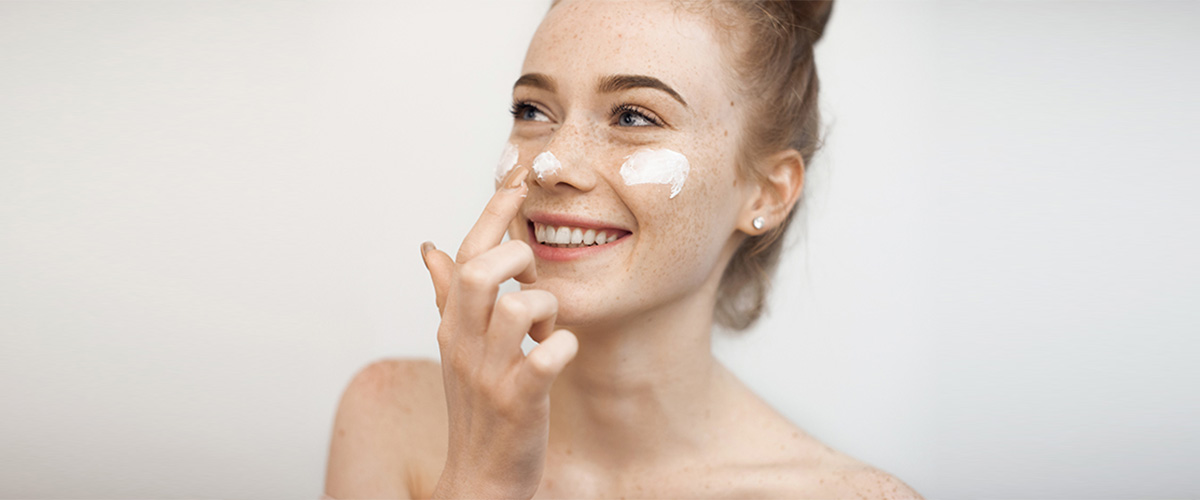 woman moisturising face 